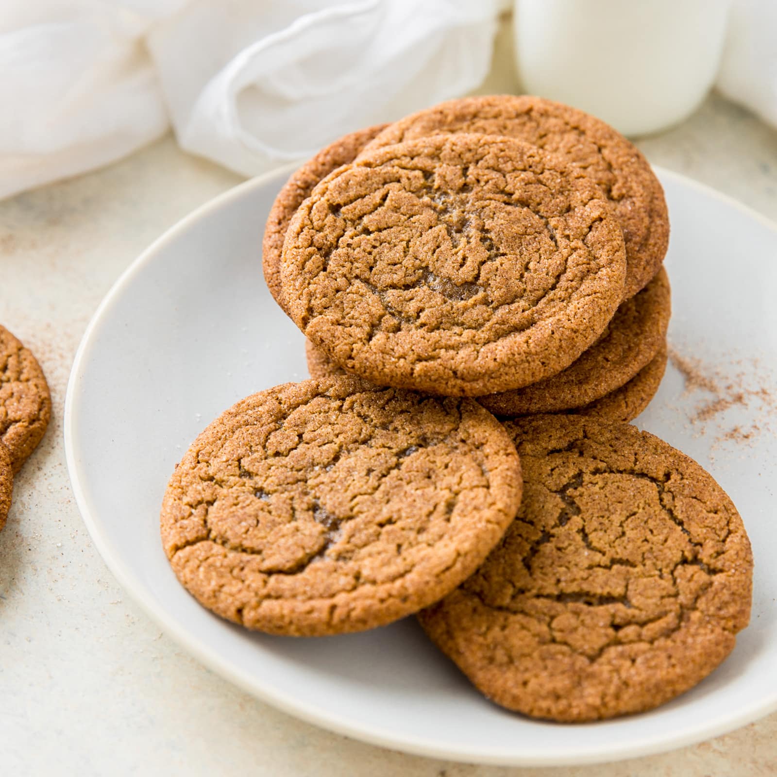 pile of ginger molasses cookies on light grey plate