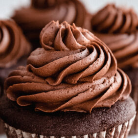 chocolate buttercream frosting on top of cupcakes