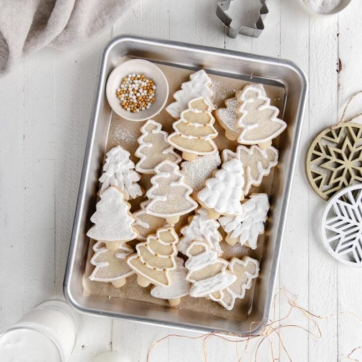 iced cut out christmas tree sugar cookies on rectangle baking sheet