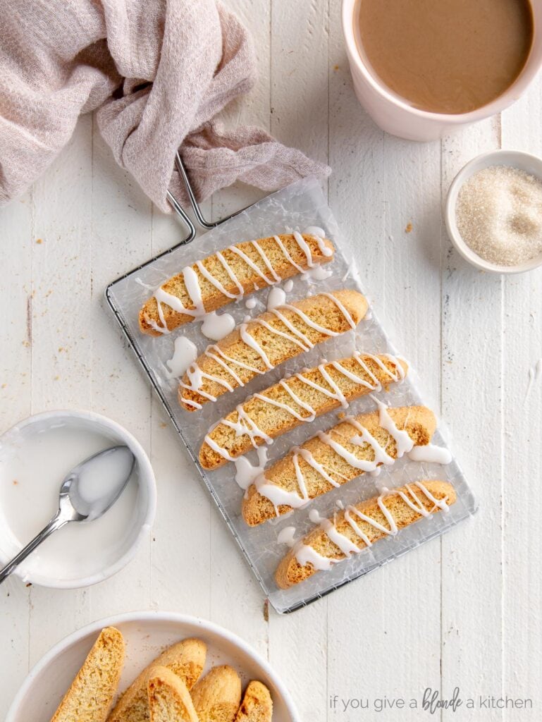 biscotti with icing drizzled on top on rectangle wire cooling rack with handle