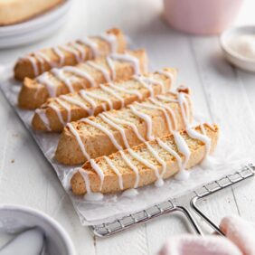 homemade biscotti topped with a drizzled icing on wire cooling rack