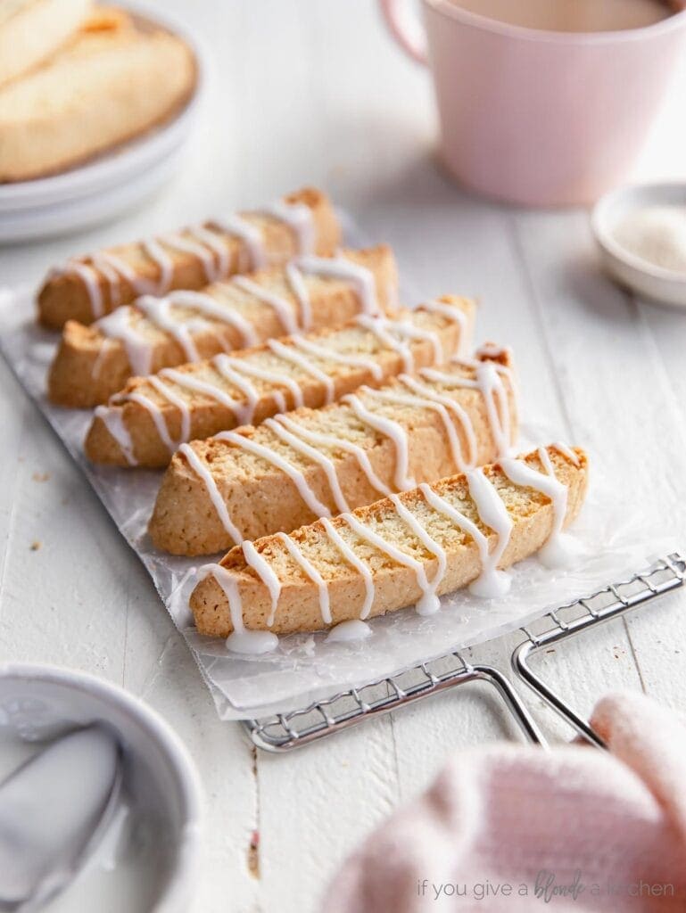 homemade biscotti topped with a drizzled icing on wire cooling rack