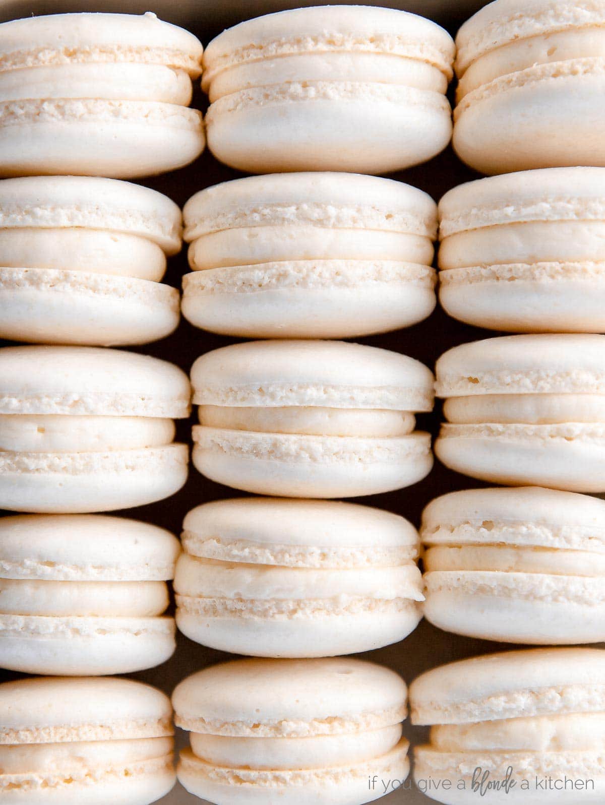 french macarons lined up on their side showing feet and buttercream filling