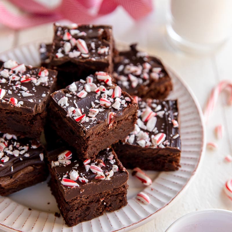 plate of chocolate brownies topped with chocolate ganache and crushed candy cakes