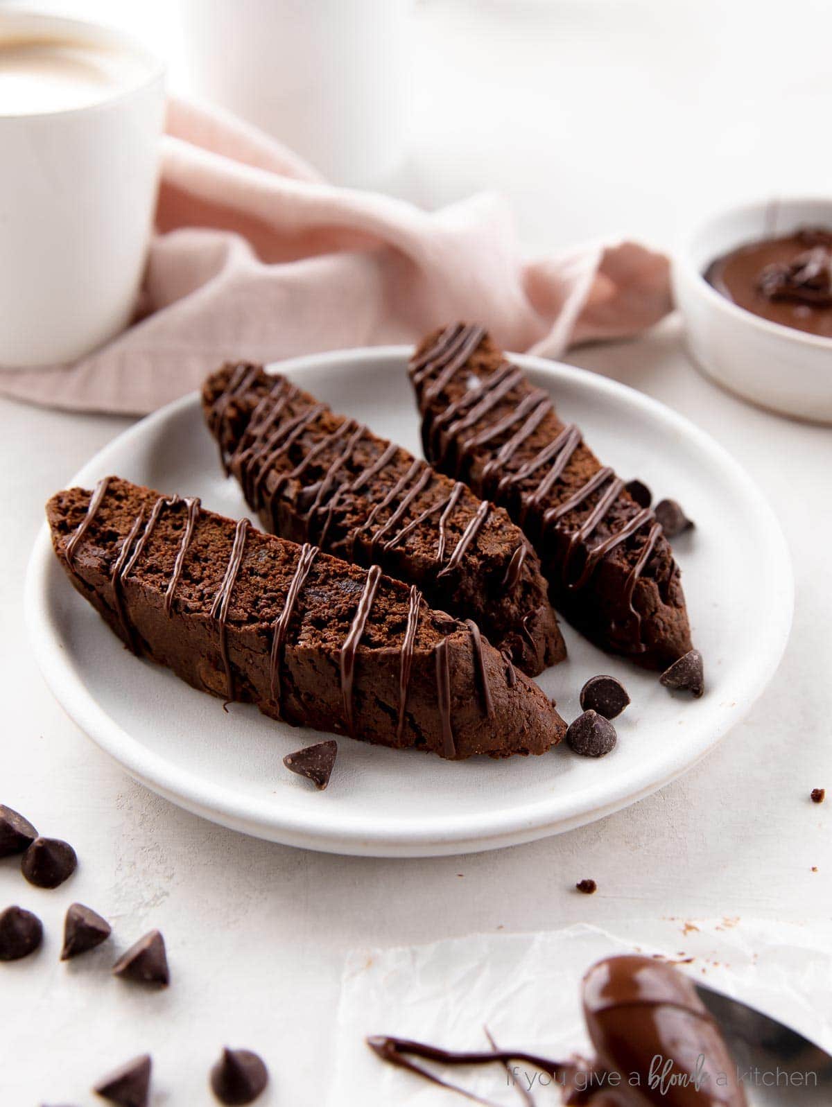 three chocolate biscotti on a round white plate