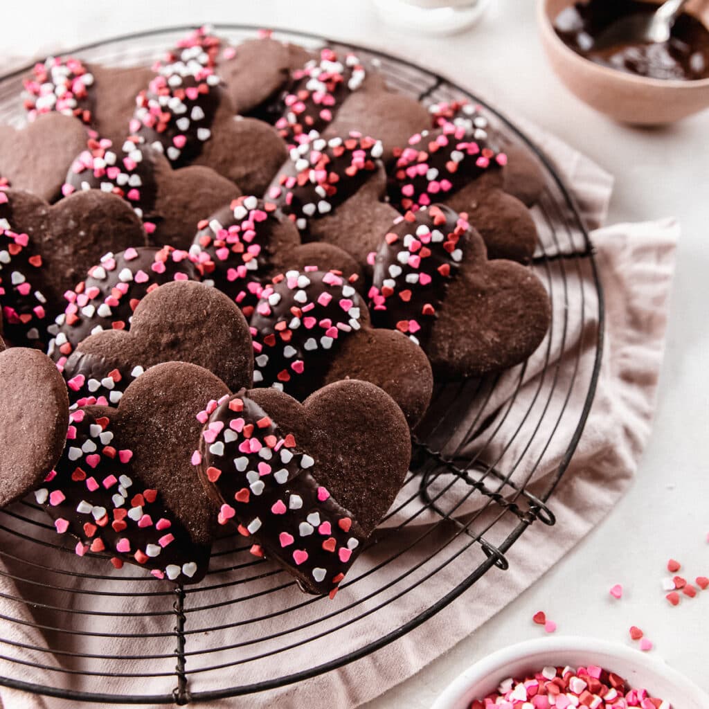 chocolate heart cookies half dipped in chocolate with pink sprinkles