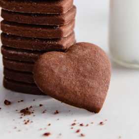 heart shaped chocolate cut out cookie leaning up against stack of cookies