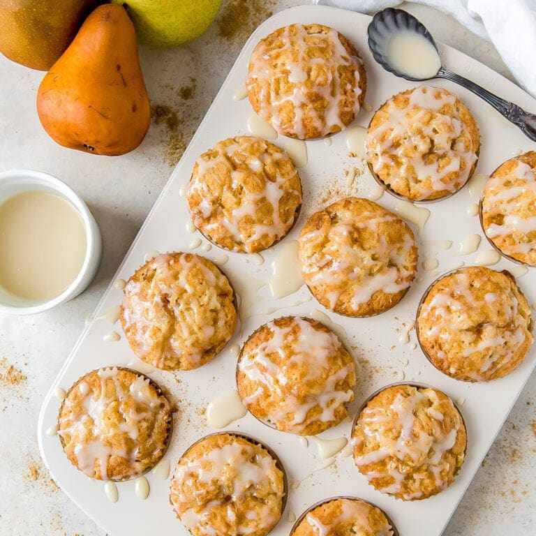 ginger pear muffins in pan with glaze on top