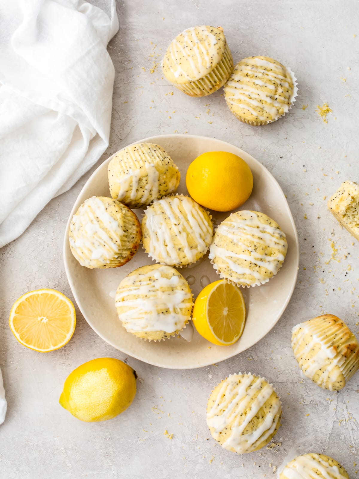 lemon poppy seed muffins and lemon wedges on a plate and table surface