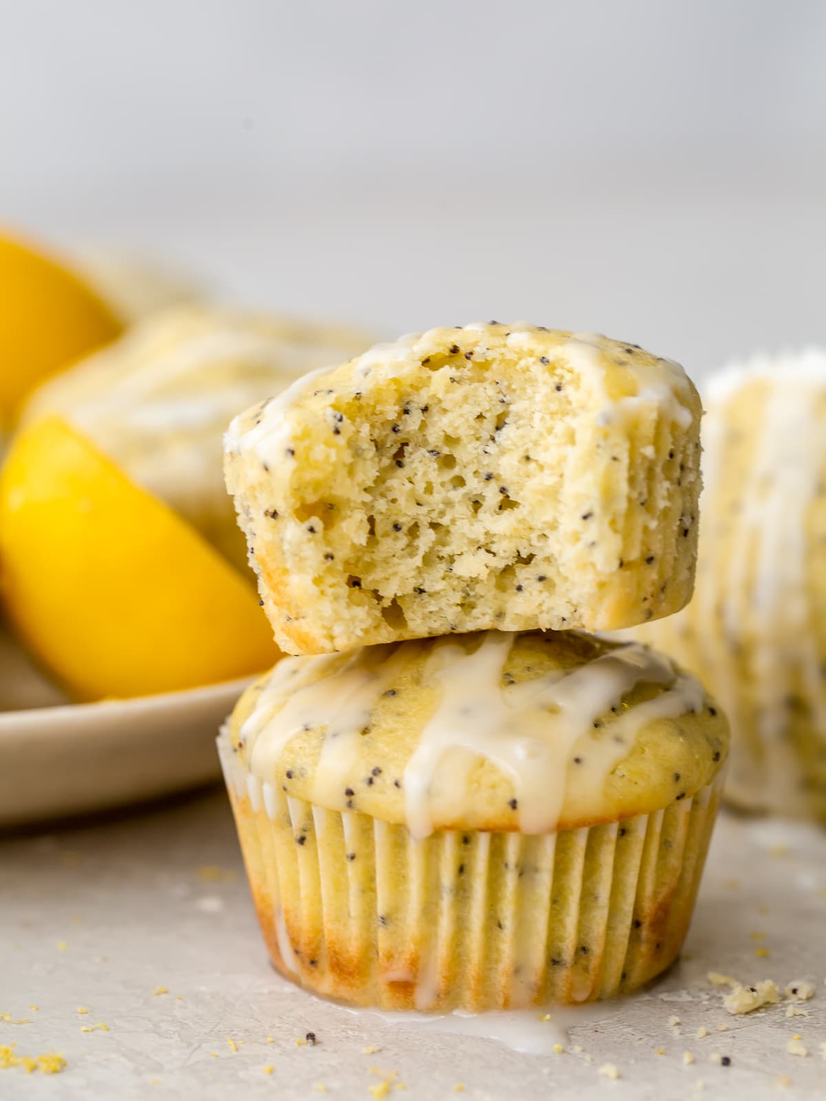 lemon poppy seed muffin with a bite stacked on top of another muffin