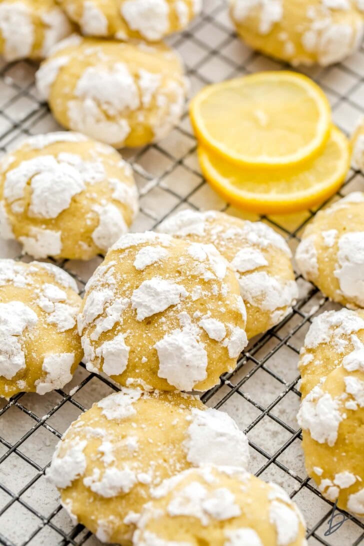 lemon crinkle cookies with confectioners sugar piled on wire rack