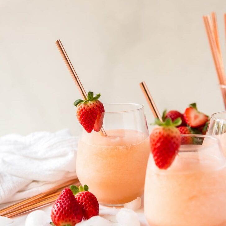 wine glasses filled with frozen rose, garnished with a strawberry