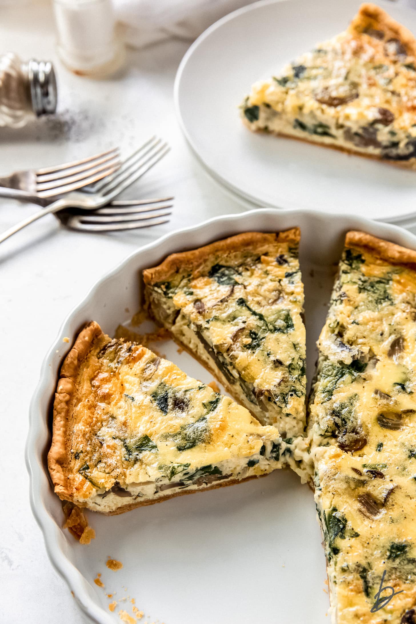 slices of quiche in a ceramic quiche dish