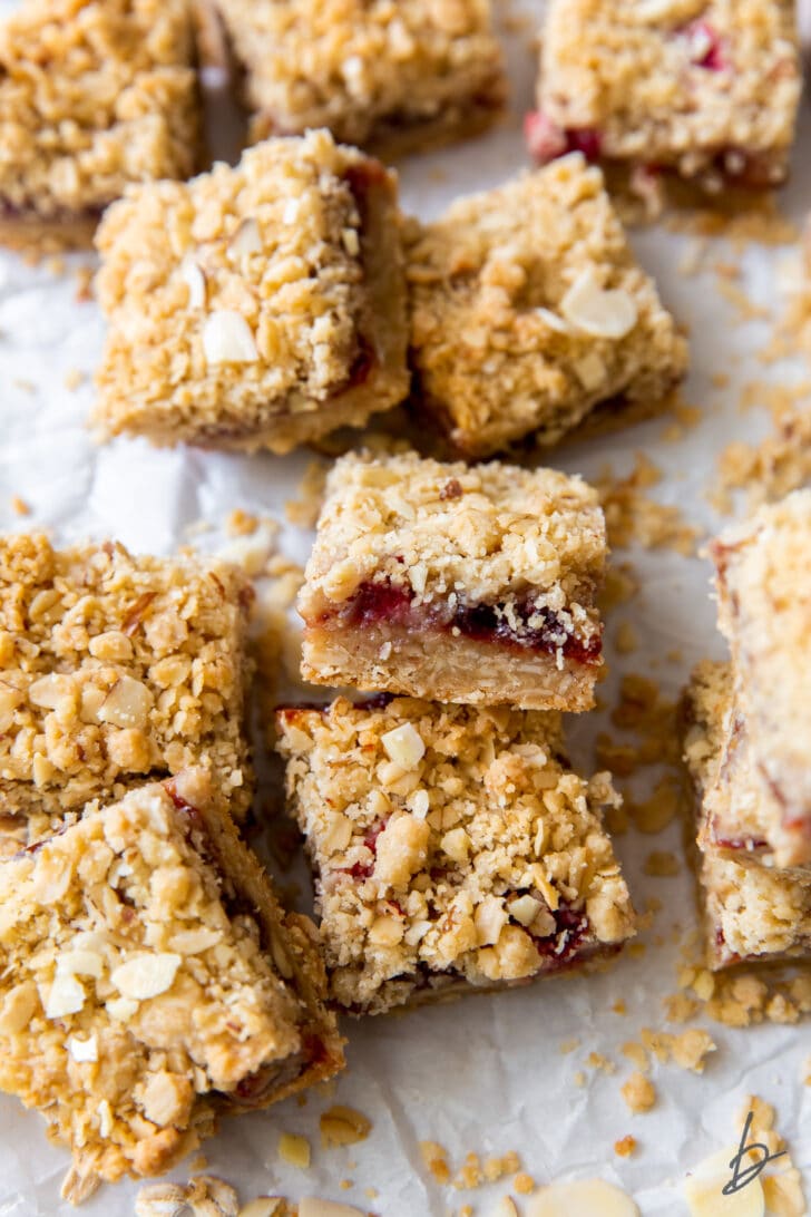 strawberry oatmeal bar propped on top of another bar showing layers of crumble and preserves