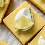 key lime pie square garnished with whipped cream and lime slice