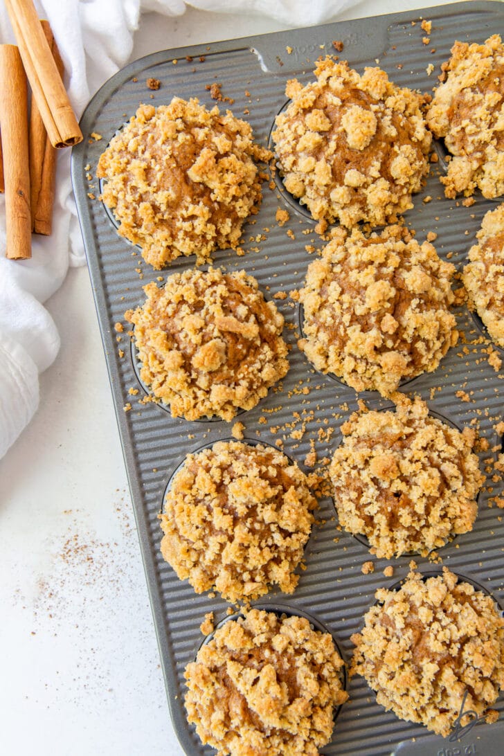 pumpkin muffins in pan with streusel topping on muffins and pan