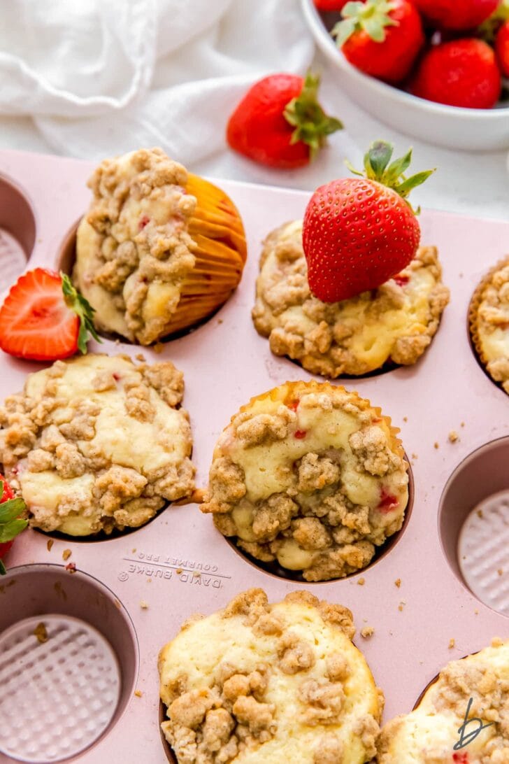 strawberry muffins with streusel topping in pink muffin pan