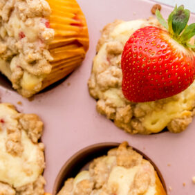 strawberry muffins with streusel topping in a pink muffin with