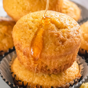 honey dripping down cornbread muffin stacked on another muffin