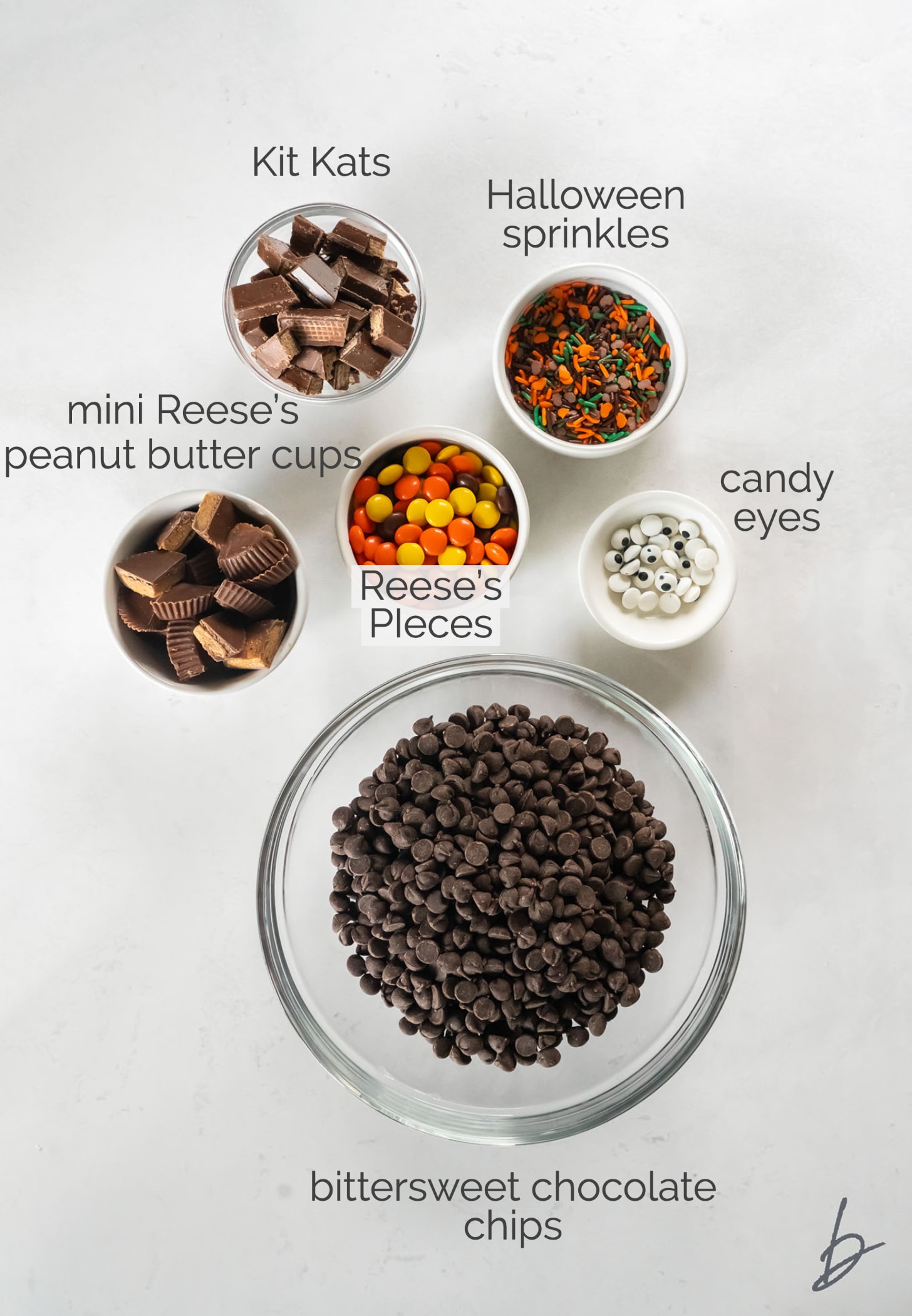 halloween candy bark ingredients in bowls labeled with text