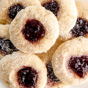 raspberry jam thumbprint cookies on white round plate