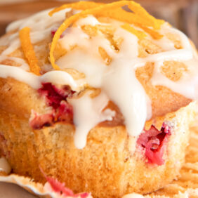 cranberry orange muffin with glaze on open muffin liner