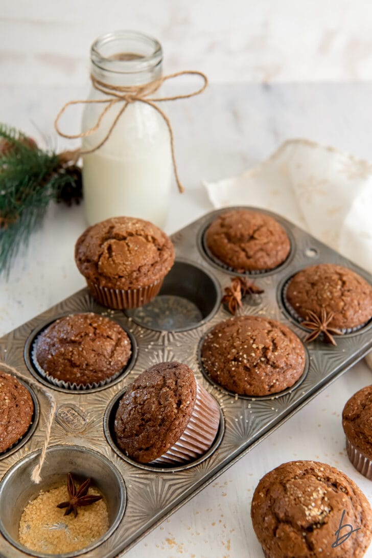 gingerbread muffins in antique muffin tin in front of milk bottle