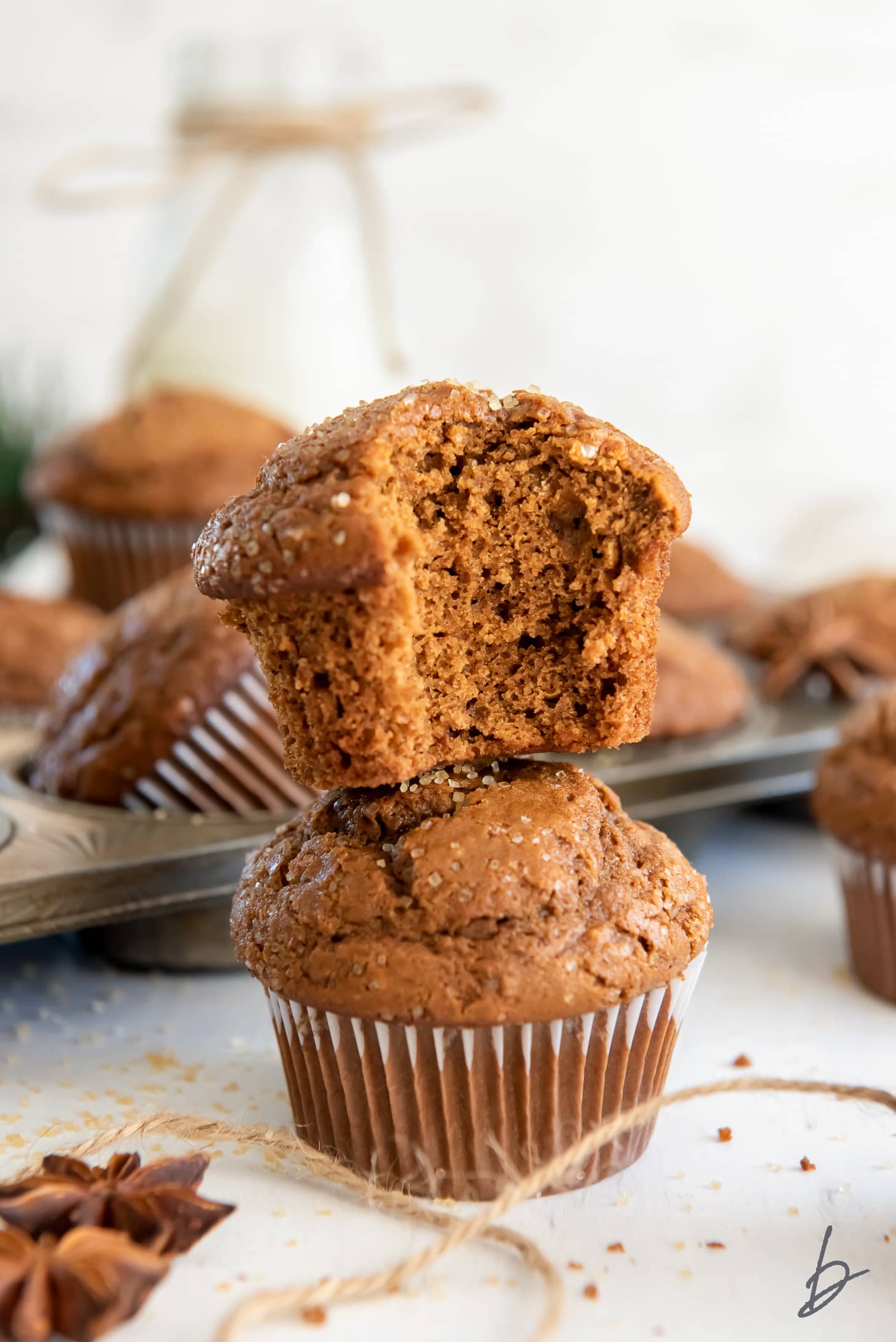 gingerbread muffin with a bite stacked on top of another gingerbread muffin.