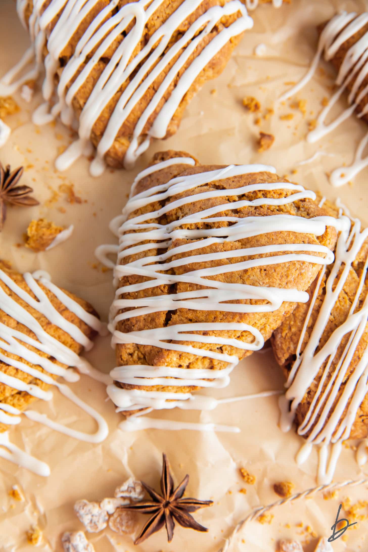 gingerbread scone with maple glaze on parchment paper with more scones