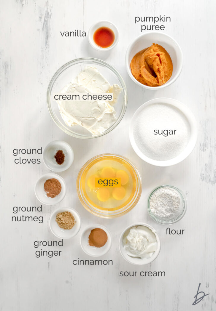 pumpkin cheesecake ingredients in bowls labeled with text
