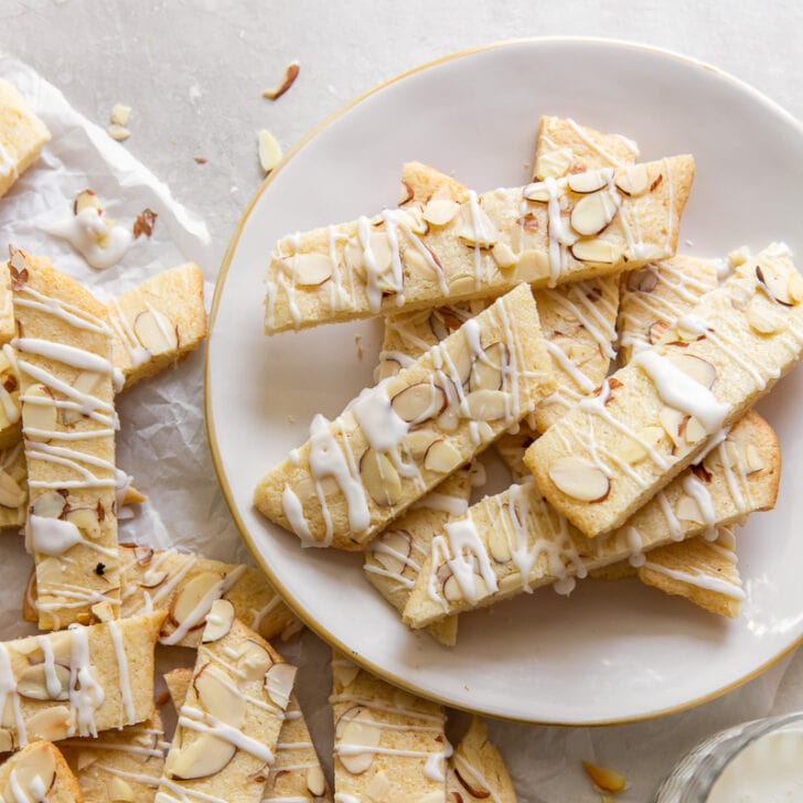 scandinavian almond bars drizzled with simple icing and topped with slivered almondson a plate