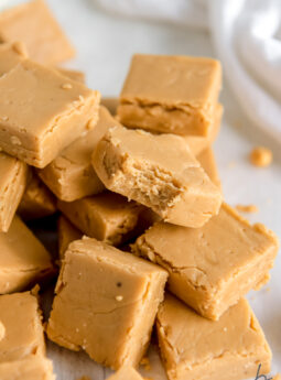 pile of peanut butter fudge and front piece has a bite from the corner