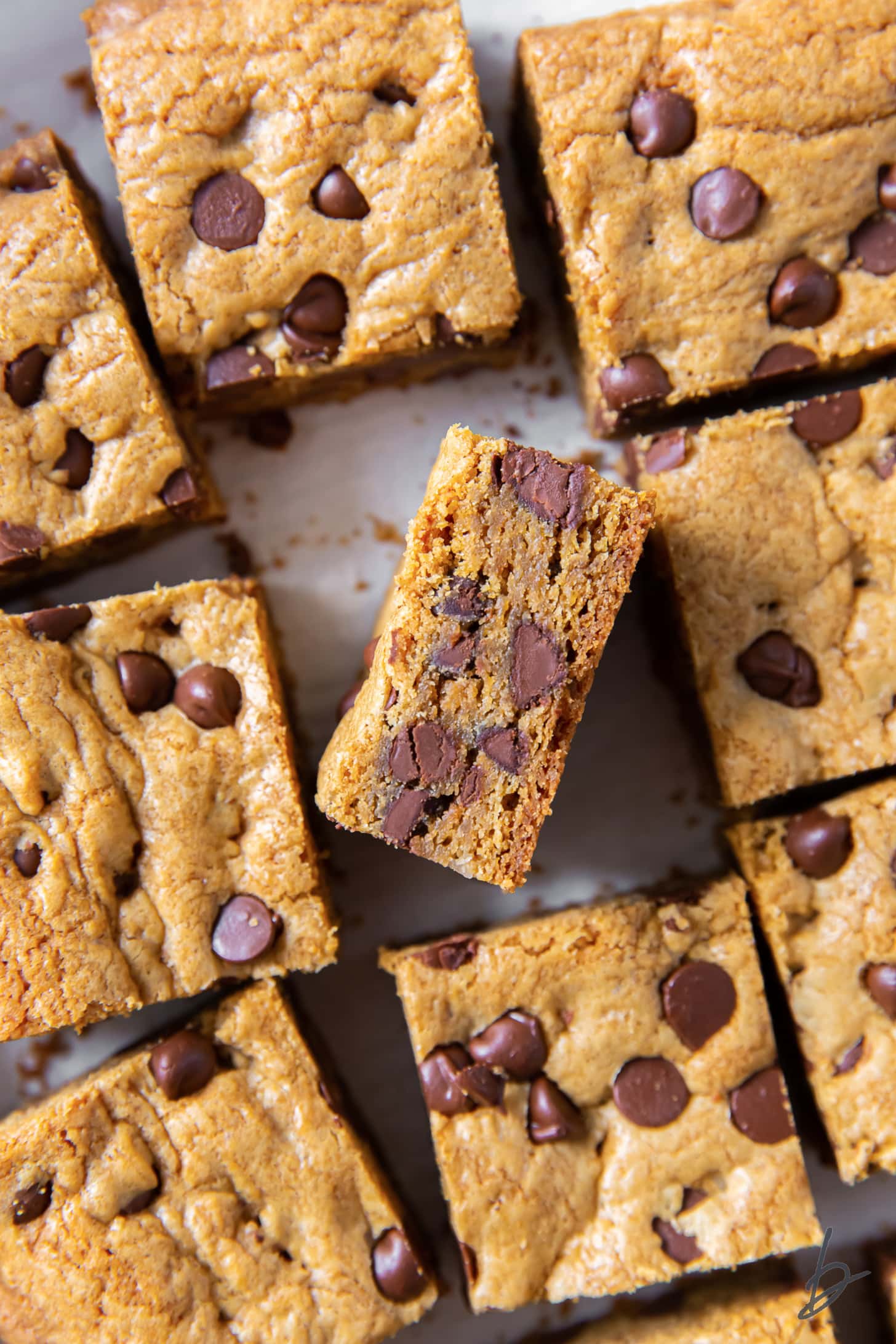 tops of chocolate chip cookie bars with one bar turned on its side to show chocolate chips inside.