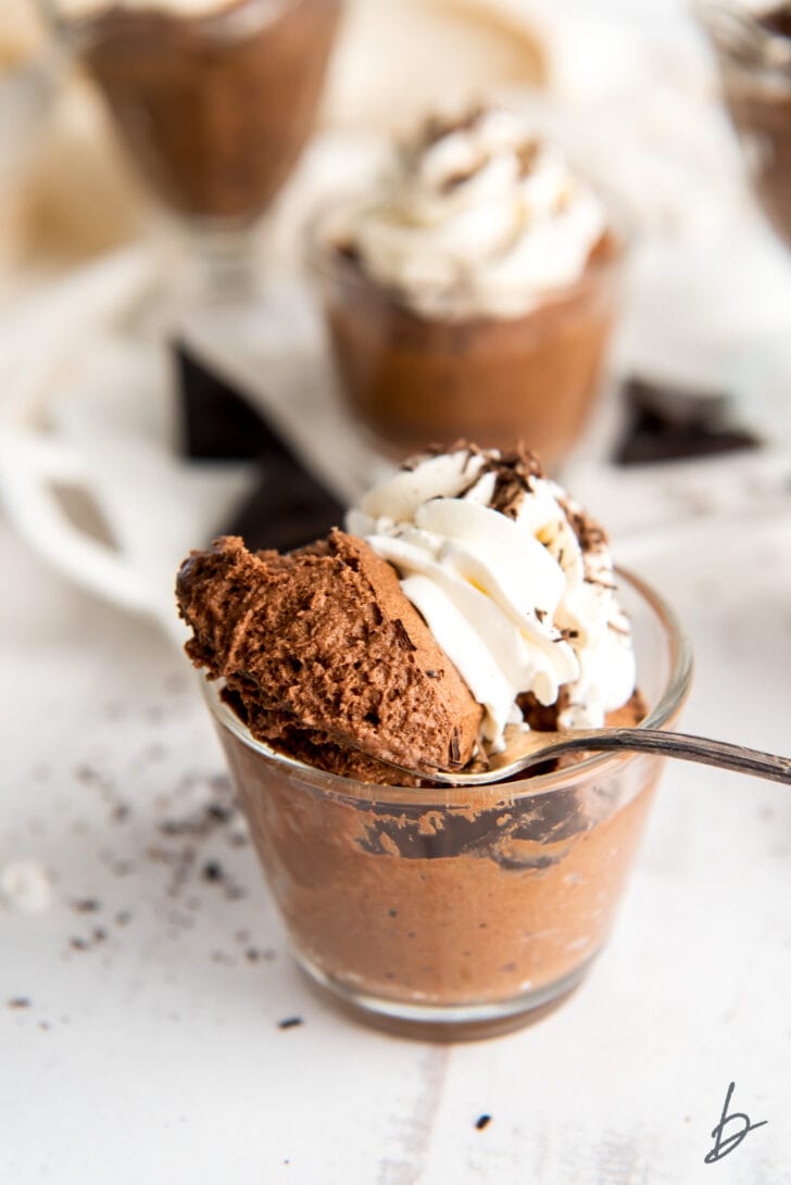 spoon taking bite of chocolate mousse out of glass jar