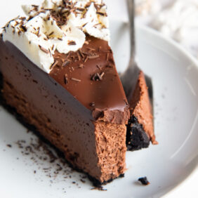 slice of chocolate cheesecake on a plate with fork holding a bite