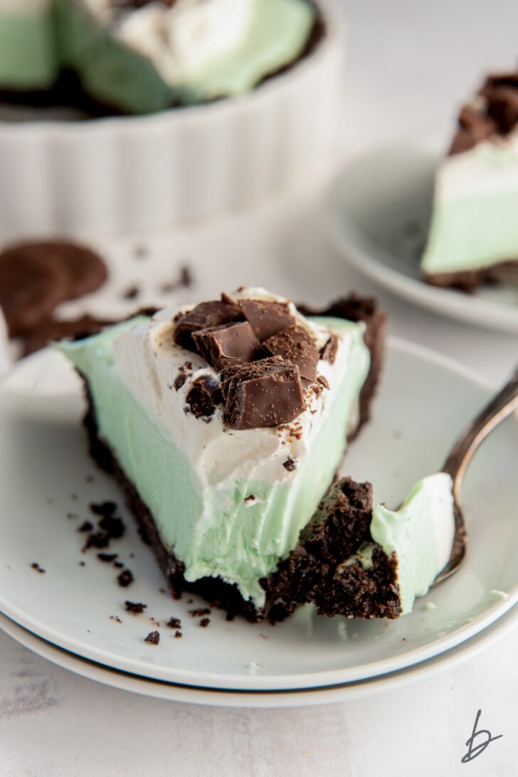 slice of grasshopper pie with fork holding a bite with cookie crust