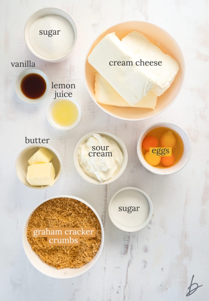 homemade cheesecake ingredients in bowls labeled with text