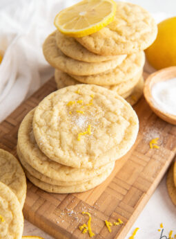 lemon sugar cookies in stacks on brown cutting board