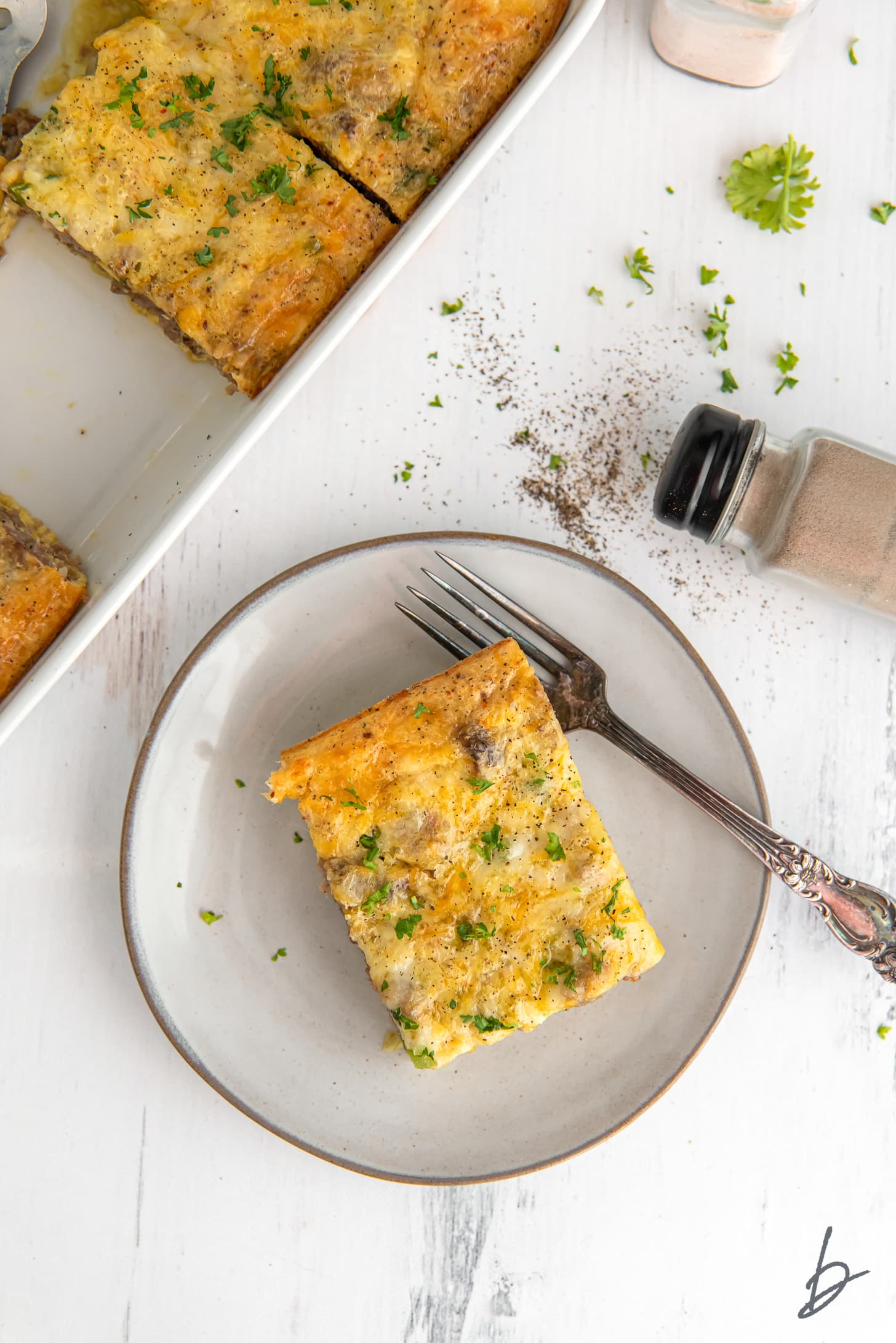 rectangle slice of sausage breakfast casserole on a plate with a fork