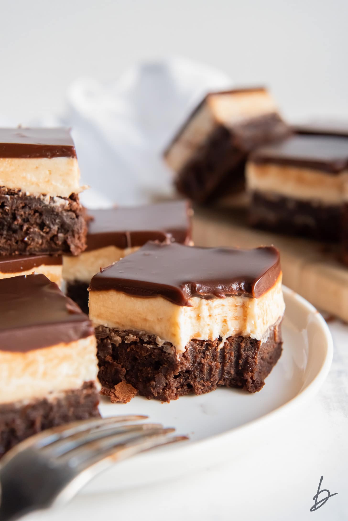 Baileys brownie with frosting and ganache with a bite taken out of it.