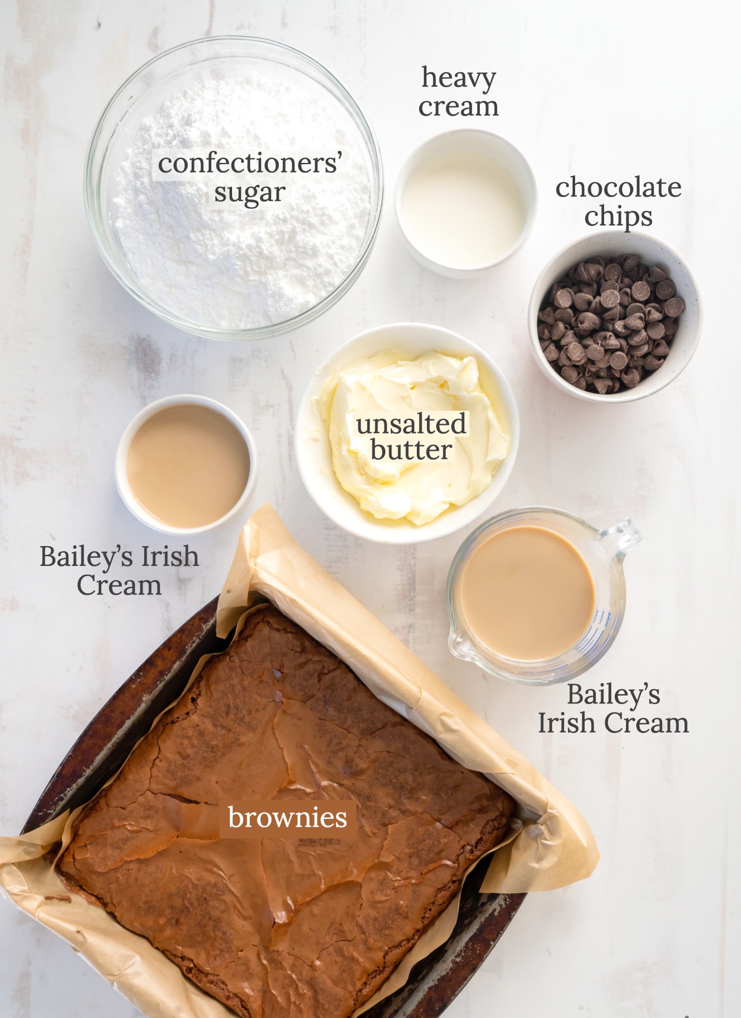 baileys brownies ingredients in bowls labeled with text.