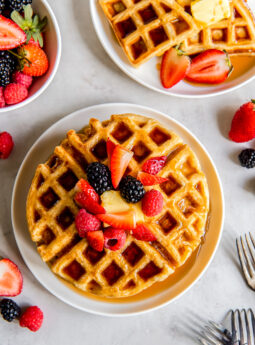 plate of buttermilk waffles topped with syrup and fresh berries