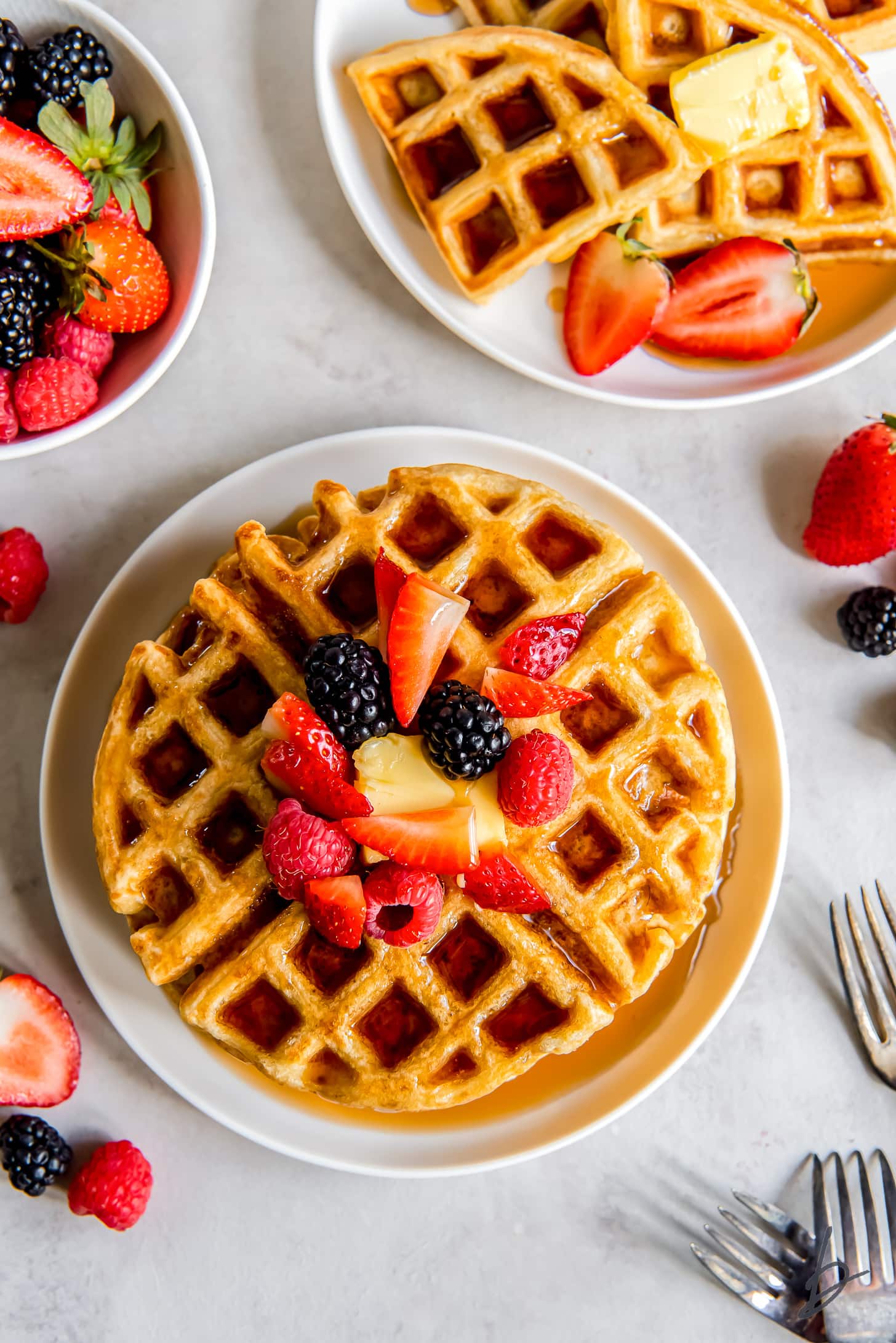 plate of buttermilk waffles topped with syrup and fresh berries