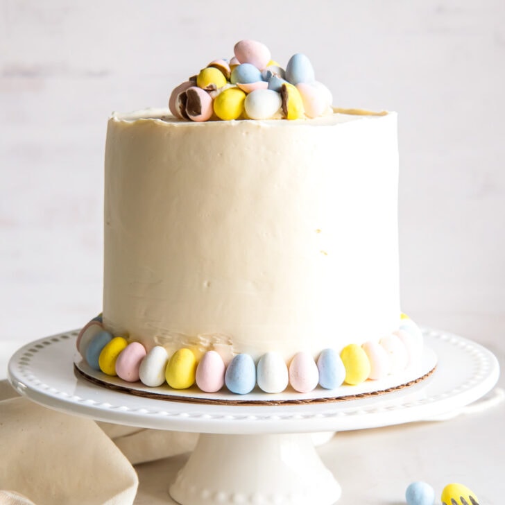 vanilla layer cake with cadbury mini eggs as garnish on white cake stand