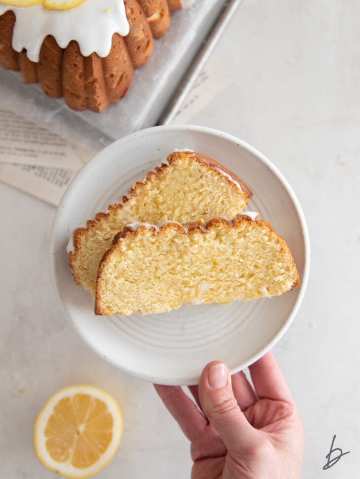 hand holding plate with two slices of lemon pound cake on it