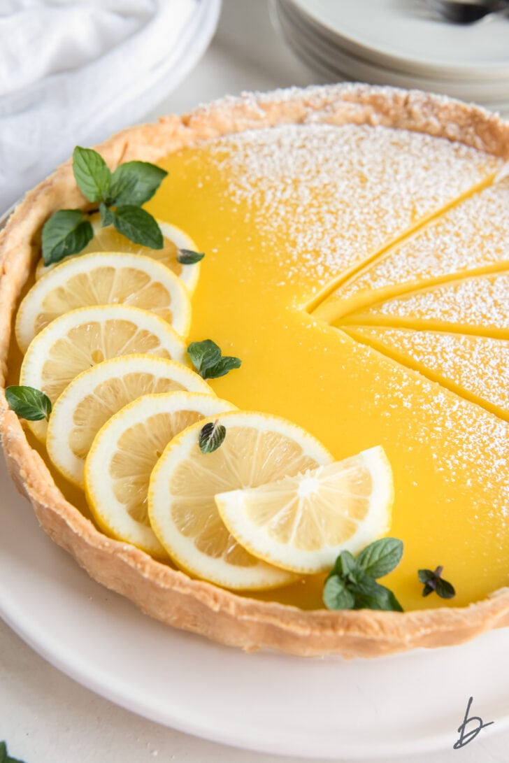 lemon slices and mint leaves on a lemon curd tart