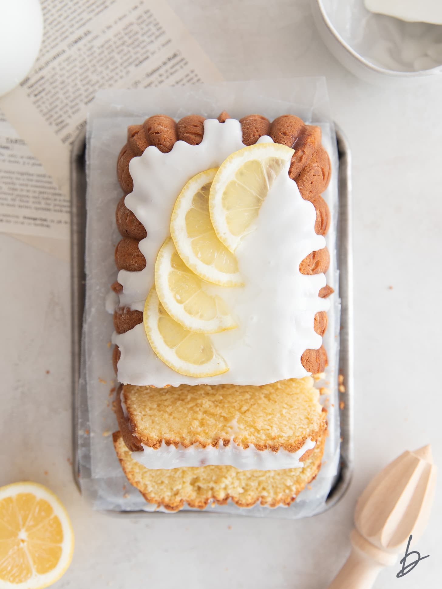 lemon pound cake with icing and two slices cut off the end of the loaf