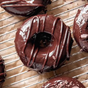 chocolate donuts with chocolate glaze on wire cooling rack