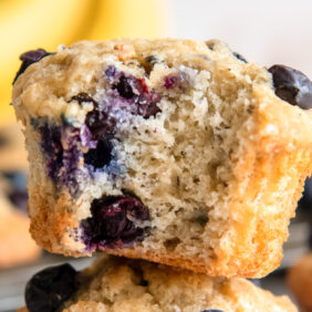 blueberry banana muffin with a bite showing blueberries inside