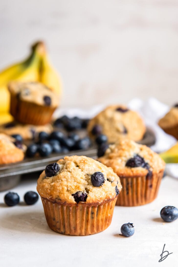 blueberry banana muffin in front of more muffins and muffin tin